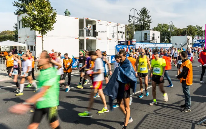 Teilnehmer des Berlin-Marathons passieren temporäre Containeranlagen von Zeppelin Rental im Zielbereich