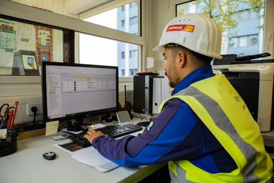 Mitarbeiter von Zeppelin Rental arbeitet mit digitalem Baustellenmanagement-System am Arbeitsplatz